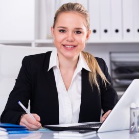 Successful businesswoman using laptop at workplace