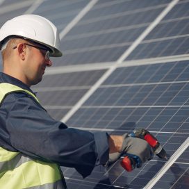 Engineer in a white helmet. Man near solar panel.